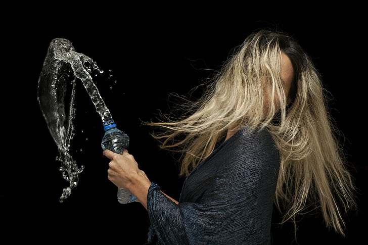 woman holding plastic bottle with water