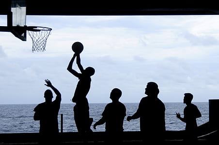 silhouette of people playing basketball at daytime