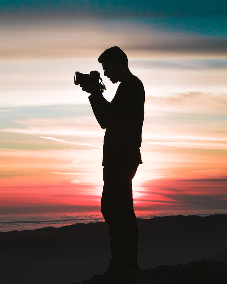 silhouette of a man holding a camera