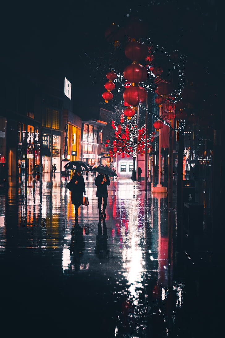 two people walking white holding umbrellas