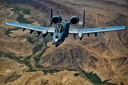 Gray Jet Fighter Flying Above Brown Mountain