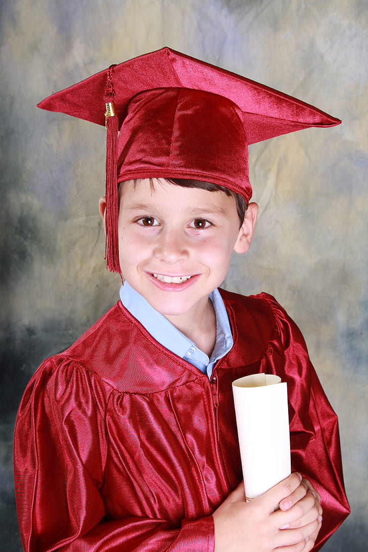 boy wearing red academic gown with mortar board