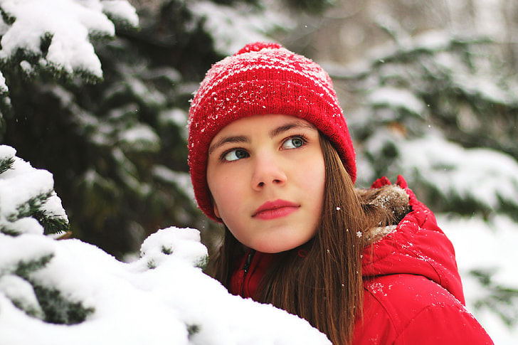 Girl wearing hat in winter snow and ice