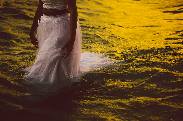 woman wearing dress walking on body of water