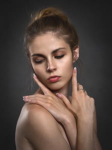 topless woman wearing red lipstick with hand gestures on face
