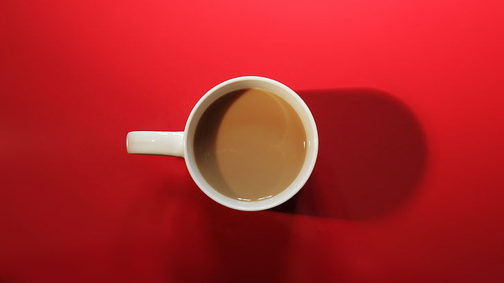 above angle photo of white ceramic mug with brown coffee in it