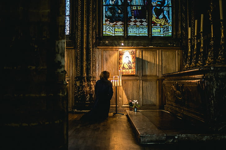 person kneeling inside cathedral