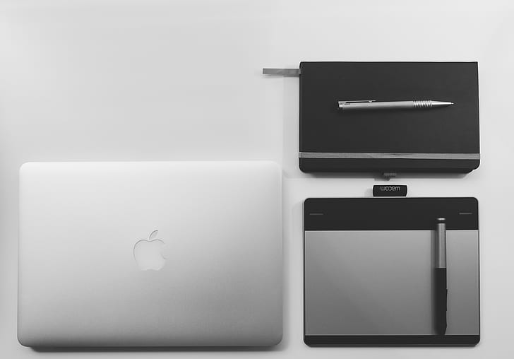 silver MacBook beside pentab