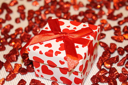 white and red heart print box with bow on white textile