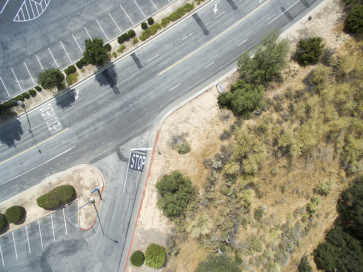 aerial photography of gray road near green grass and trees during daytime