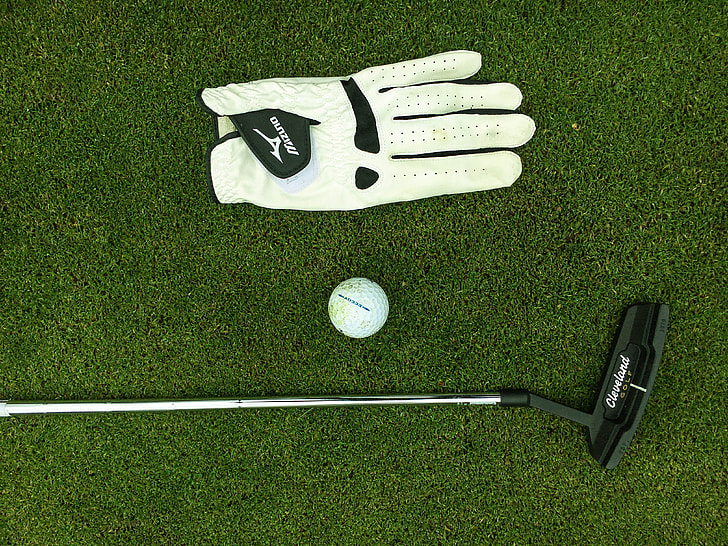close up photo of black golf putter, white golf ball and unpaired white glove