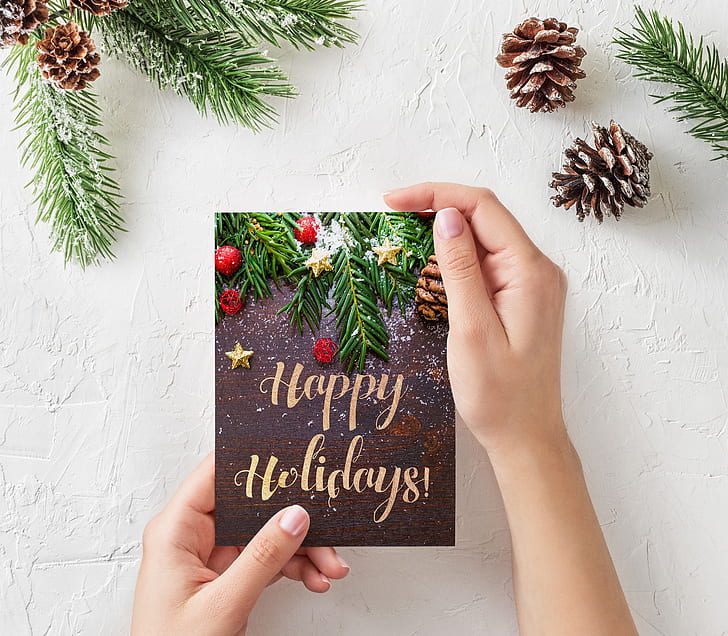person holding Happy Holidays greetings card