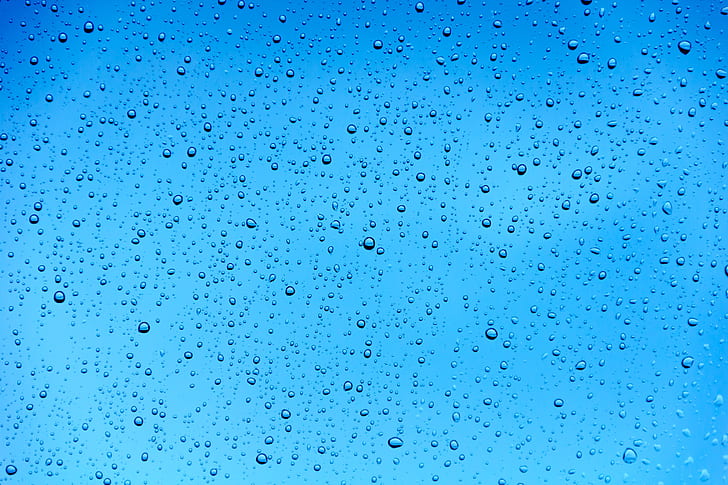 close-up photo of water drops under blue sky during daytime