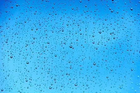 close-up photo of water drops under blue sky during daytime