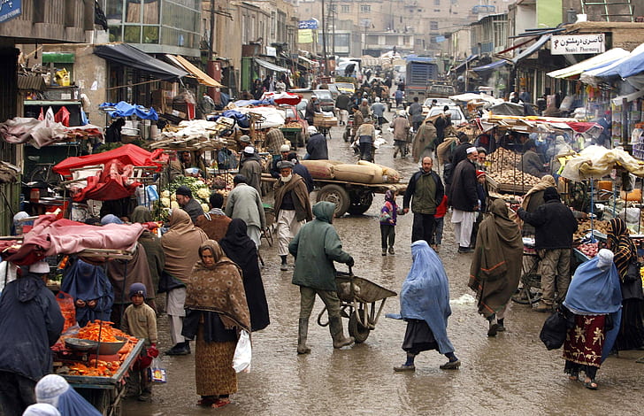 people wearing capes walking on street near market