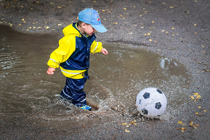 boy playing soccer ball during daytime