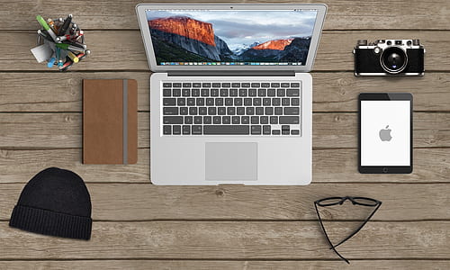 MacBook Air beside brown tablet computer case