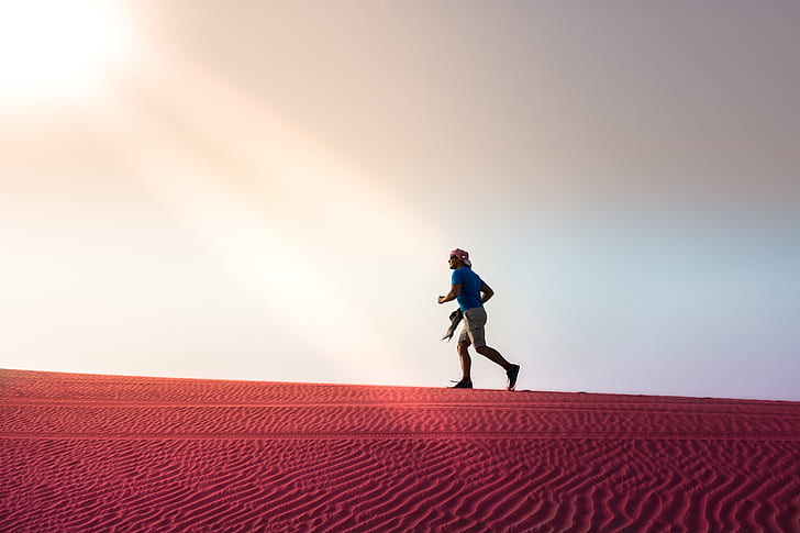 man running on desert during daytime