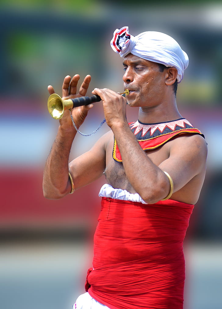 man playing brass flute at daytime