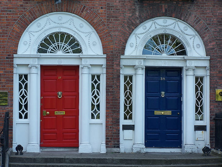two red and blue wooden door close near gray concrete pavement at daytime