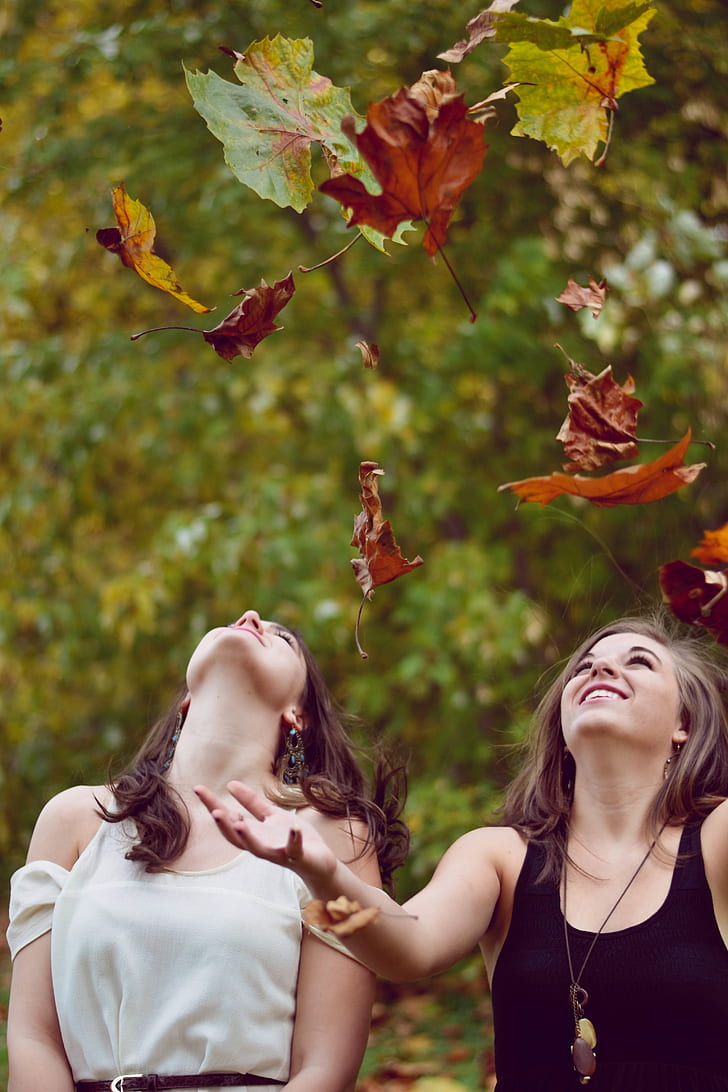 two women throwing leaves