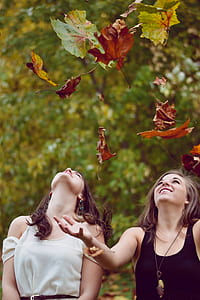 two women throwing leaves