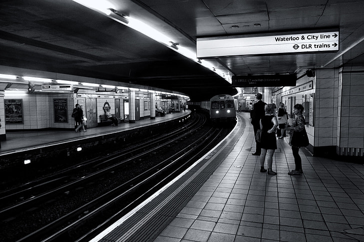 Monochrome shot of subway passengers as they wait for their train on the London Underground
