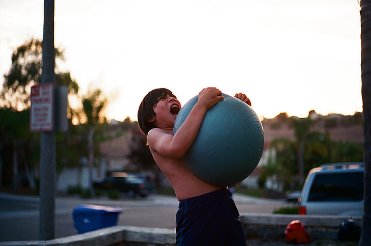 boy holding blue fitness ball