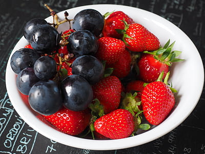 strawberries with grapes in white ceramic bowl