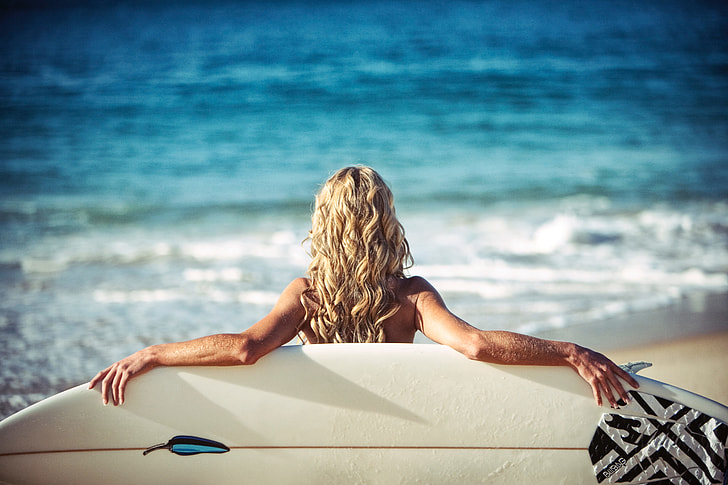 Woman on summer beach with surfboard