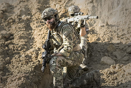 man wearing combat suit holding rifle
