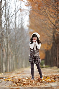 standing girl wearing white and brown hooded top at daytime