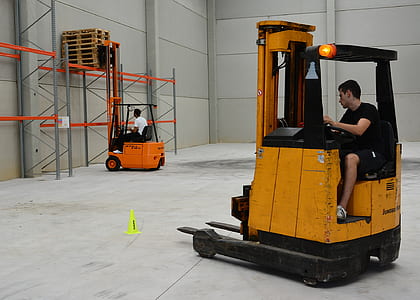 photo of two men in forklifts