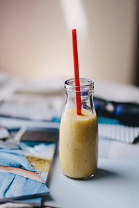 Healthy shake in a small bottle with a straw and sunglasses