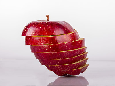 sliced red apple on white surface