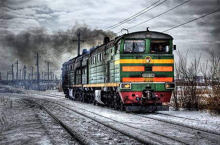 green and orange locomotive taken during daytime