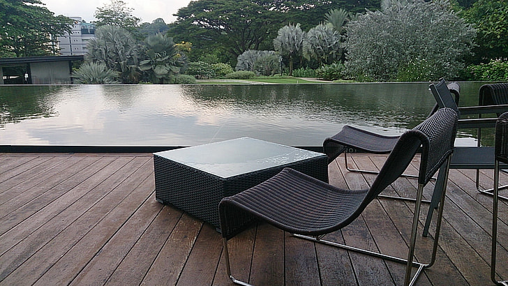 black patio chairs beside body of water