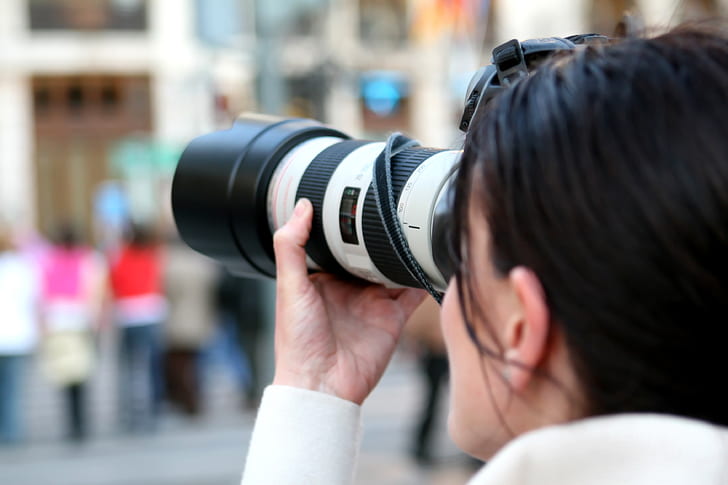 woman adjusting DSLR zoom lens