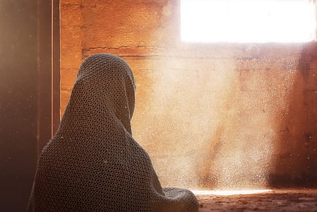 person with headscarf looking in the window wallpaper