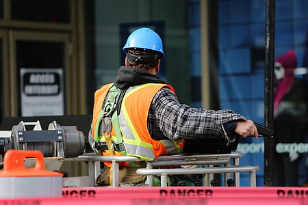 man wearing black and white plaid long-sleeved shirt and blue hard hat