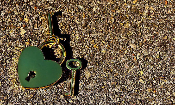 green heart padlock with keys on brown surface