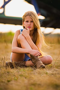 girl sits on green grass field