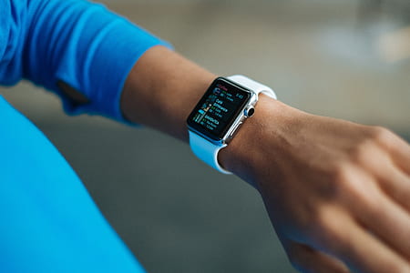 person using silver aluminum Apple Watch with white Sport Band photography