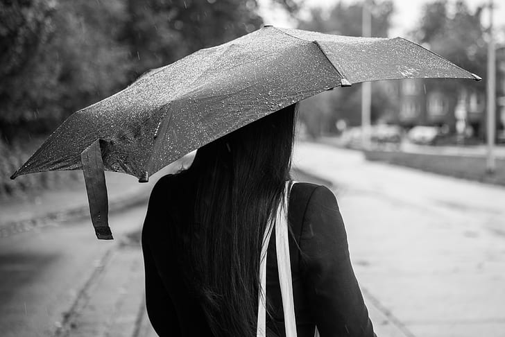 woman using umbrella grayscale photo