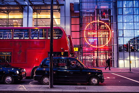 Red buses and black taxis sit on a busy London street