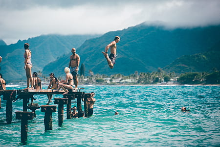 man jumping unto body of water