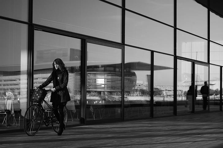 woman holding bicycle grayscale photo