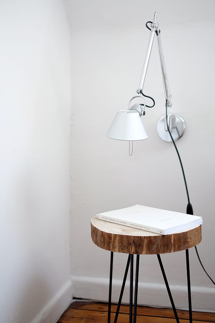 book on brown wooden table near wall