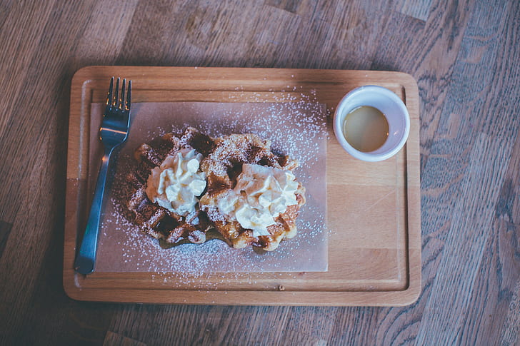 pancake on wooden tray beside cup
