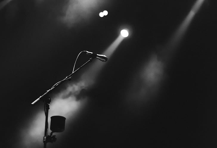 grayscale photo of microphone and stage lights